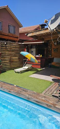 un ombrello sull'erba accanto a una casa di Casa con piscina en San Bernardo a Santiago