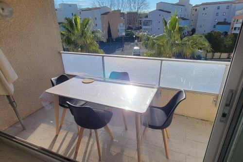 une table et des chaises sur un balcon avec vue dans l'établissement Nauticap, Joli T2 rénové, piscine, parking, 200m plage, au Cap d'Agde