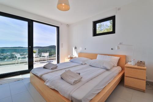 - une chambre avec un grand lit et une grande fenêtre dans l'établissement Ferienhaus Petites Maures, Meerblick und eigener Pool, à Roquebrune-sur Argens