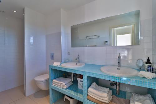 La salle de bains est pourvue de 2 lavabos, d'un miroir et de toilettes. dans l'établissement Ferienhaus Petites Maures, Meerblick und eigener Pool, à Roquebrune-sur Argens