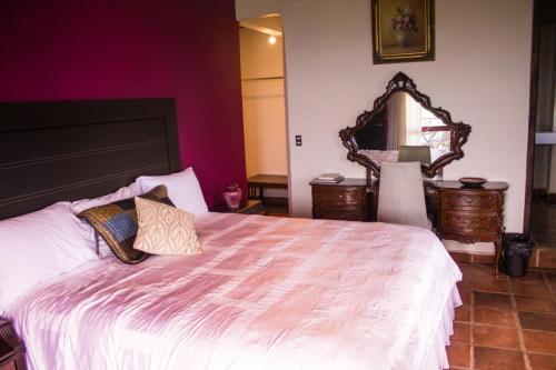 sypialnia z dużym łóżkiem z dużym lustrem w obiekcie Solache Inn w mieście Zitácuaro