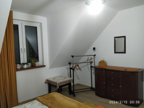 a bedroom with a bed and a dresser and a mirror at Dolistówka Apartamenty, pole namiotowe, balia z jacuzzi, ogród warzywny dla gości, plac zabaw dla dzieci in Goniadz