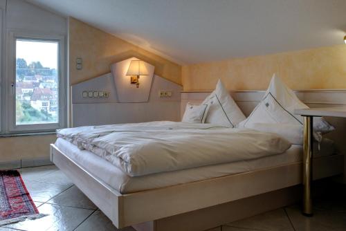 a bedroom with a large white bed with a window at Hotel Mühlenthal GmbH in Schwalbach
