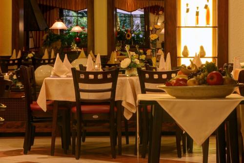 a dining room with a table with a bowl of fruit on it at Hotel Mühlenthal GmbH in Schwalbach