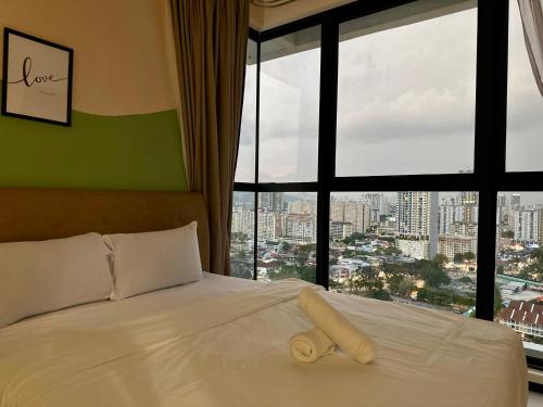 a bedroom with a white bed with a large window at Urban Suite Spacious 2 or 3 Bedroom and 2Bathroom at Georgetown by URBAN STAYCATION HENG LOD in Jelutong