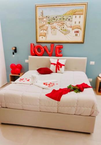a bedroom with a bed with a love sign on it at Suite san Giorgio in Gravina in Puglia