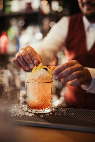 a bartender is preparing a drink in a glass at Hotel Lech Da Sompunt in Badia