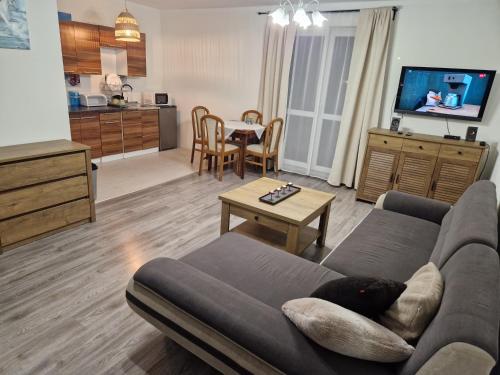 een woonkamer met een bank en een tafel bij Apartament Komorniki - Osiedla na Skraju Lasu in Komorniki