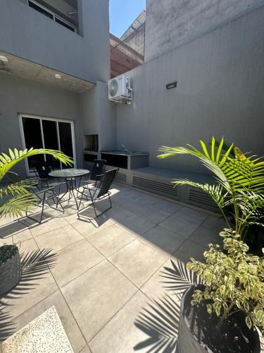eine Terrasse mit einem Tisch, Stühlen und Pflanzen in der Unterkunft Park Garden Tucumán in San Miguel de Tucumán