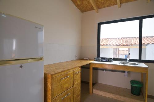 a kitchen with a sink and a window at Encosta Azul Guesthouse in Cidade Velha