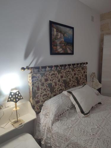 的住宿－Las Palmeras，一间卧室配有一张床和一张带台灯的桌子