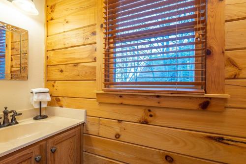 a bathroom with a sink and a window at The Mountain Hideout~Swings~Hot Tub~Views~Decks in Swiss