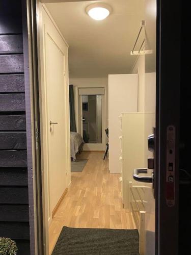 a hallway leading to a room with a refrigerator at Modern studio apartment in fantastic nature in Tromsø