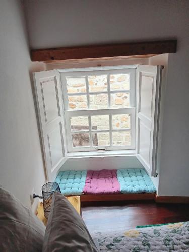 a window with a colorful seat in front of it at Recanto da Pedra in Linhares