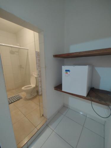 a bathroom with a toilet and a glass shower stall at Pousada Rancho Texas Ubatuba in Ubatuba