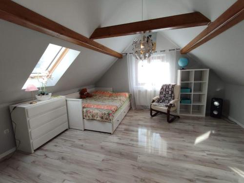 1 dormitorio en el ático con 1 cama y 1 silla en Ubytování v soukromí Karin, en Ludvíkov