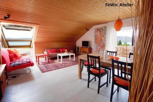 sala de estar con mesa, sillas y sofá en Atelierwohnung mit Seeblick, en Sipplingen