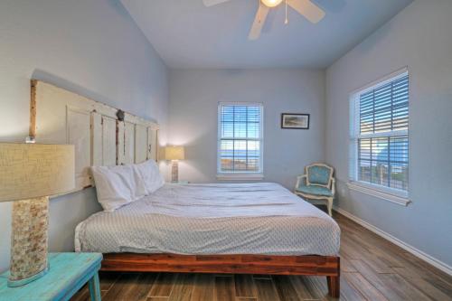 a bedroom with a large bed and two windows at Fishtastic by AvantStay Retreat w Pool Access in Padre Island