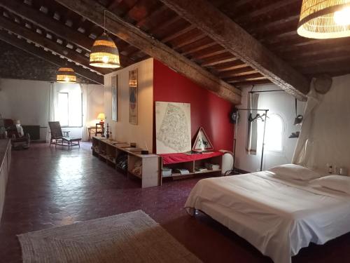 sypialnia z łóżkiem i czerwoną ścianą w obiekcie Le Mas Palegry Chambres d'hôtes Perpignan w Perpignanie