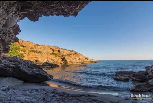 a view of the ocean through a rock cave at Votsalo Studios & Apartment in Frangokastello