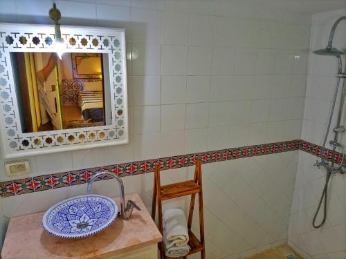 a bathroom with a sink and a mirror at Dar Baaziz 3 in Sousse
