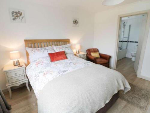um quarto com uma cama com uma almofada vermelha em The Cottage in Baxterley. Peaceful home from home. Beautifully finished. em Baxterley