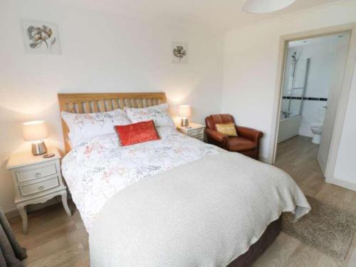 a bedroom with a bed with a red pillow on it at The Cottage in Baxterley. Peaceful home from home. Beautifully finished. in Baxterley