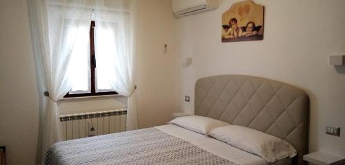 een slaapkamer met een bed en een raam bij B&B Le Cerque in Crocicchia