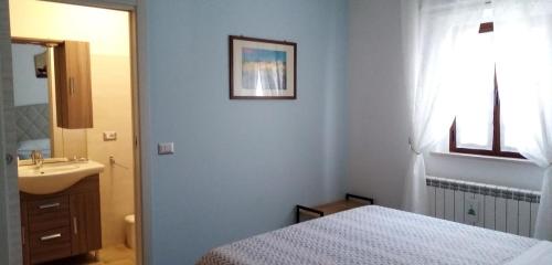 een witte badkamer met een bed en een wastafel bij B&B Le Cerque in Crocicchia
