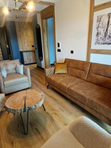 a living room with a couch and a table at Natural White apartments in Bjelašnica