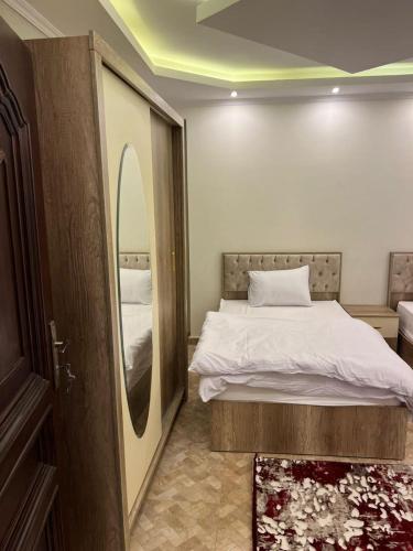 1 dormitorio con 1 cama con espejo grande en شقه فندقيه للايجار اليومي التجمع الخامس01068880306, en El Cairo