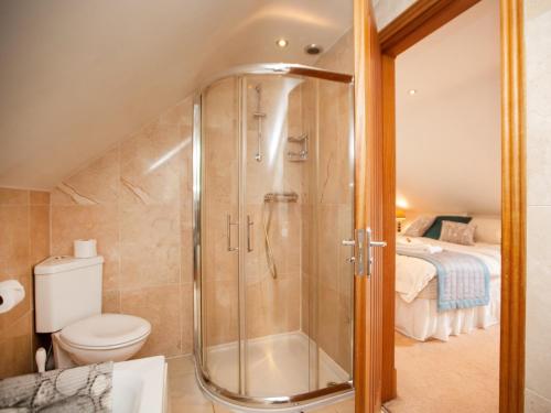 a bathroom with a shower with a toilet and a bed at 2 bed in Osmotherley G0108 in Chop Gate