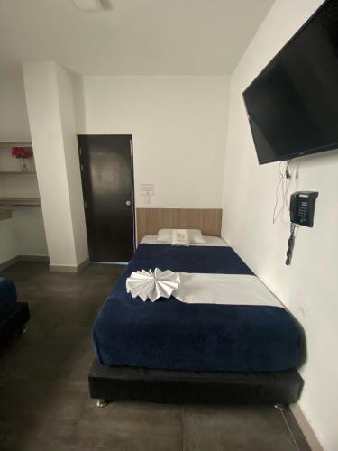 a bedroom with a blue bed with a flower on it at Hotel America 52 in Rionegro