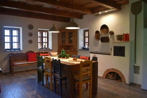 a kitchen with a table and chairs and a fireplace at Paloc Manor Vendeghaz Nagyvisnyo Romantic Heritage Guesthouse on the creek Nagyvisnyo in Nagyvisnyó
