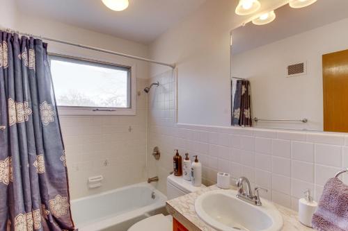 bagno con vasca, lavandino e specchio di Pet-Friendly Vacation Rental 10 Mi to Kansas City a Merriam