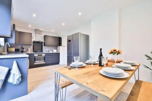 a kitchen with a wooden table with plates on it at Eco Home for Large Groups w/ FREE Parking & Wi-Fi in Bristol