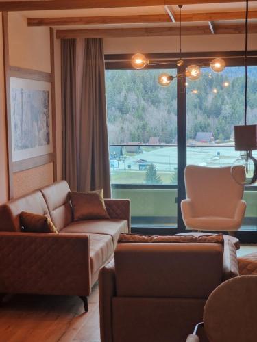 a living room with a couch and a chair at Natural White apartments in Bjelašnica