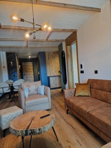 a living room with a couch and a table at Natural White apartments in Bjelašnica