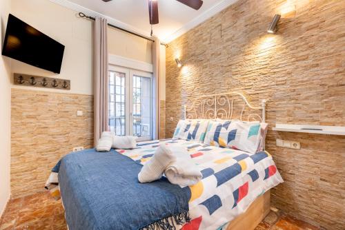1 dormitorio con cama y pared de ladrillo en Special Mcgomez next to the beach, en Málaga