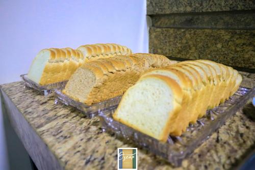 three loaves of bread sitting on a counter at Hotel Oscar Econômico Montes Claros in Montes Claros