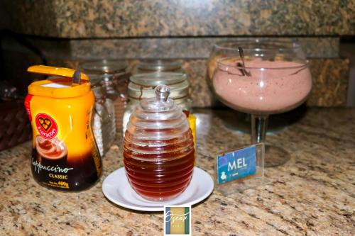 a counter top with a drink and a bottle and a glass at Hotel Oscar Econômico Montes Claros in Montes Claros