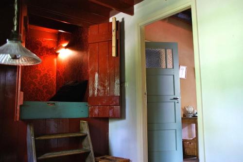 伊科斯特的住宿－De Leemstee, Authentieke boerderij met modern comfort，一间带一张双层床的客房,配有梯子和一扇门