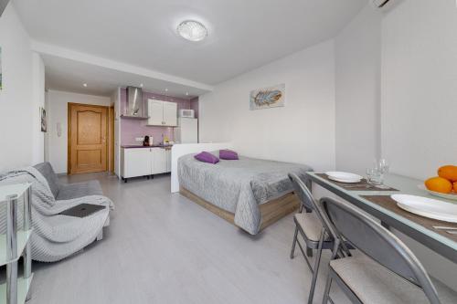1 dormitorio con cama, mesa y cocina en Estudio con Balcón Playa del Cura en Torrevieja