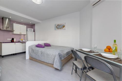 1 dormitorio con 1 cama y 1 mesa con sillas en Estudio con Balcón Playa del Cura en Torrevieja