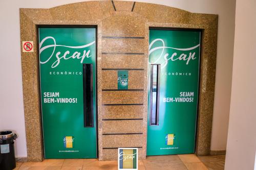 a row of green doors in a room at Hotel Oscar Econômico Montes Claros in Montes Claros