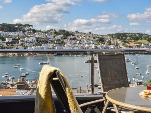 a balcony with a table and chairs and a harbor at 2 Bed in Polruan 75740 in Polruan
