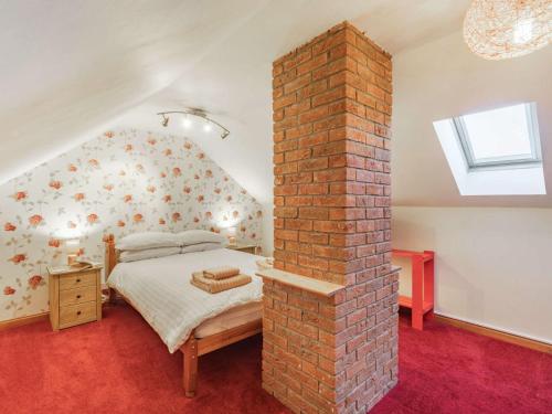 a bedroom with a brick pillar with a bed in it at 4 Bed in Warkworth 86132 in Warkworth