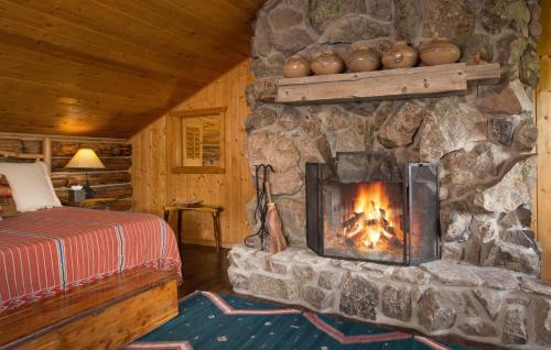 a bedroom with a stone fireplace in a cabin at Blue Lake Ranch in Hesperus