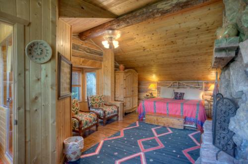 a bedroom in a log cabin with a bed and a chair at Blue Lake Ranch in Hesperus