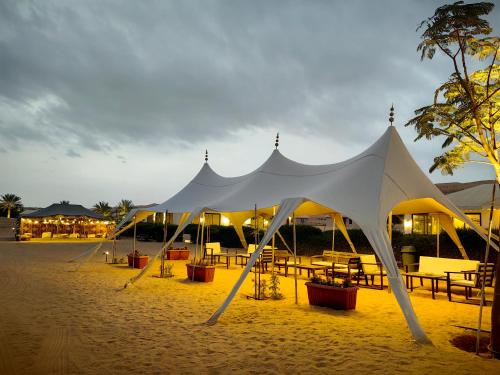 a large white tent on the beach at night at Desert Rose Camp in Bidiyah